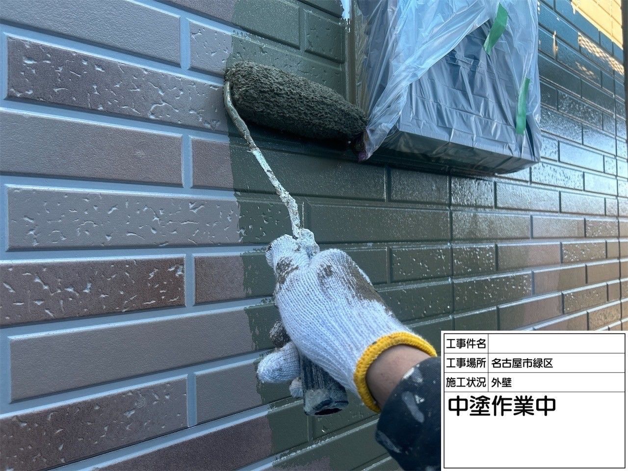 外壁の中塗り（2回目・上塗り1回目）を行っている様子