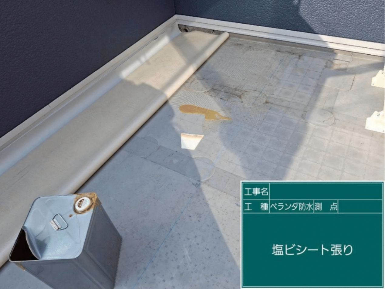 ベランダの床面に合せて塩ビ製の防水シートを隙間なく敷き込み、位置を緻密に調整する様子