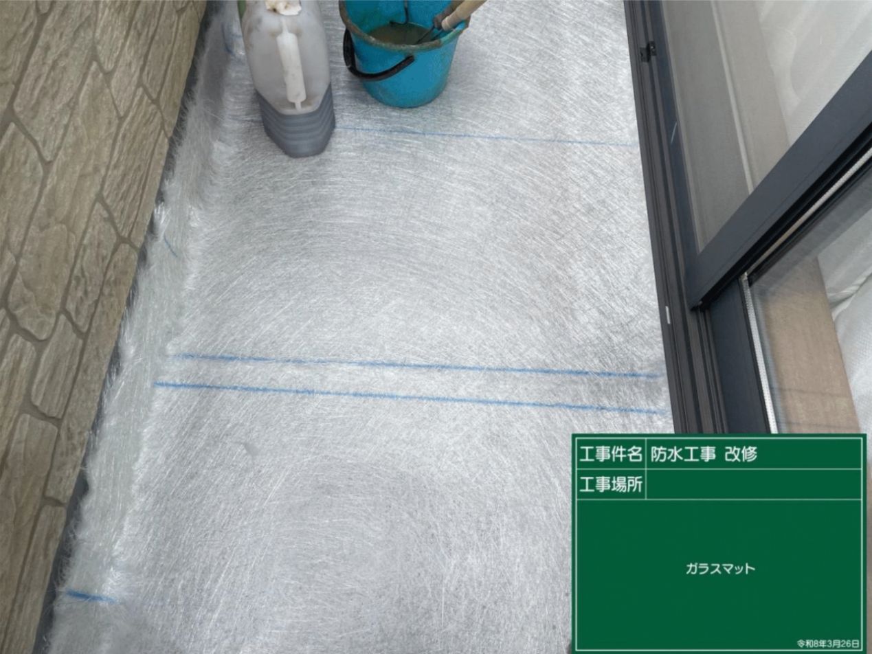 FRP防水の頑丈さを生み出すために、床面全体にガラス繊維のマットを隙間なく敷き詰めていく様子