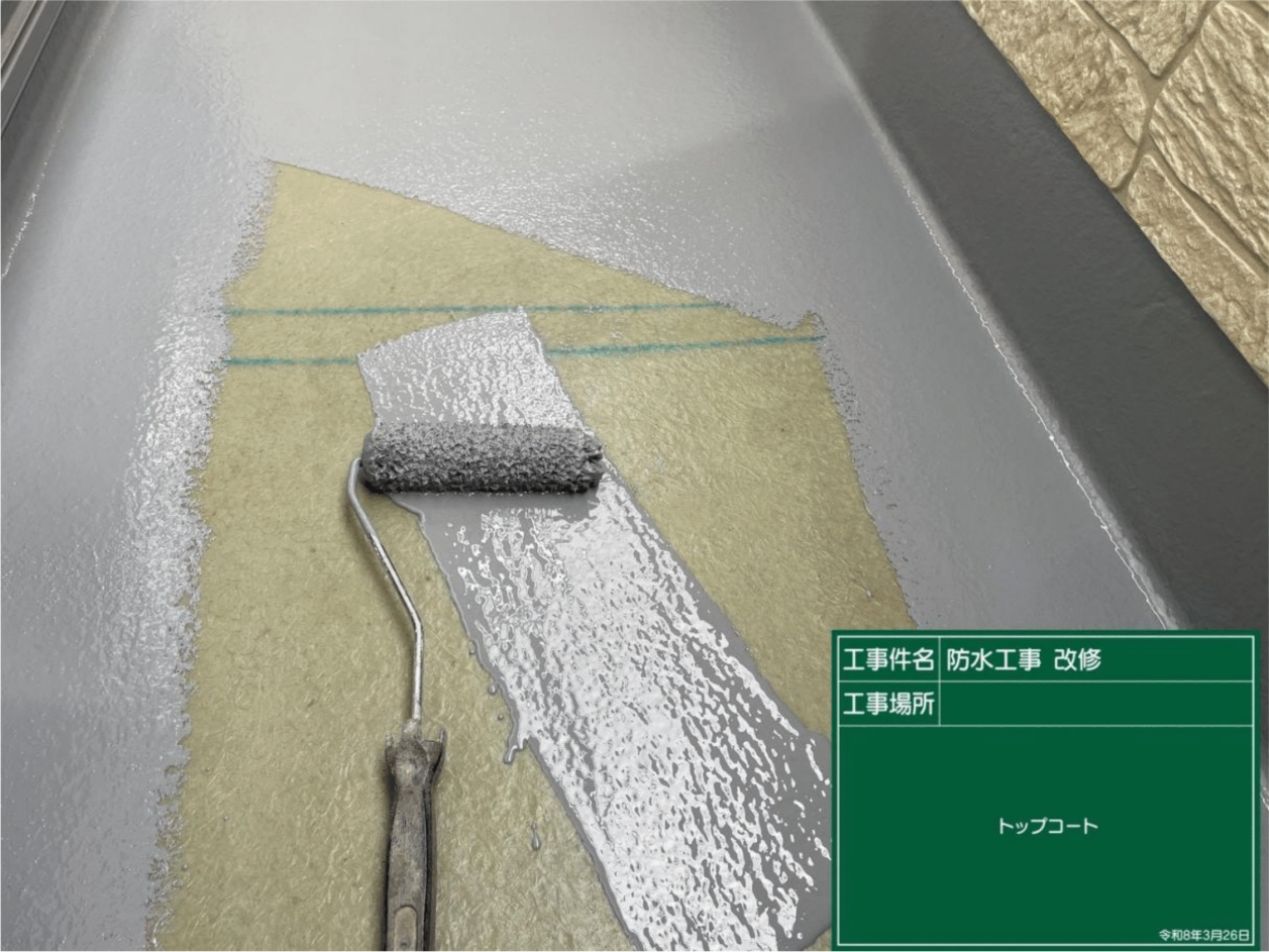 完成したFRP防水層を紫外線から長期間守るため、グレーの保護用トップコートを均一に塗る様子