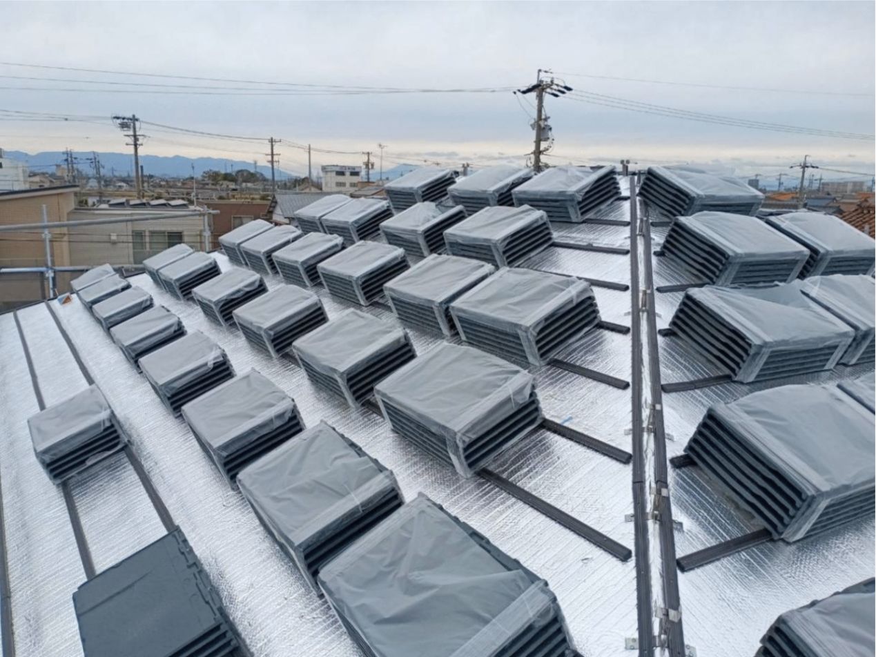 専用の昇降機(荷揚げ機)を使い、新しい金属屋根材シャネリアを安全に屋根の上へと運ぶ様子