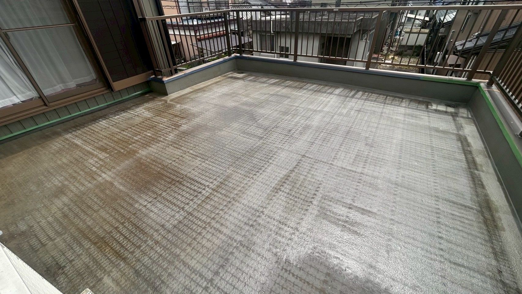 下塗りが完了し、均一なツヤと膜が張られたバルコニー床面
