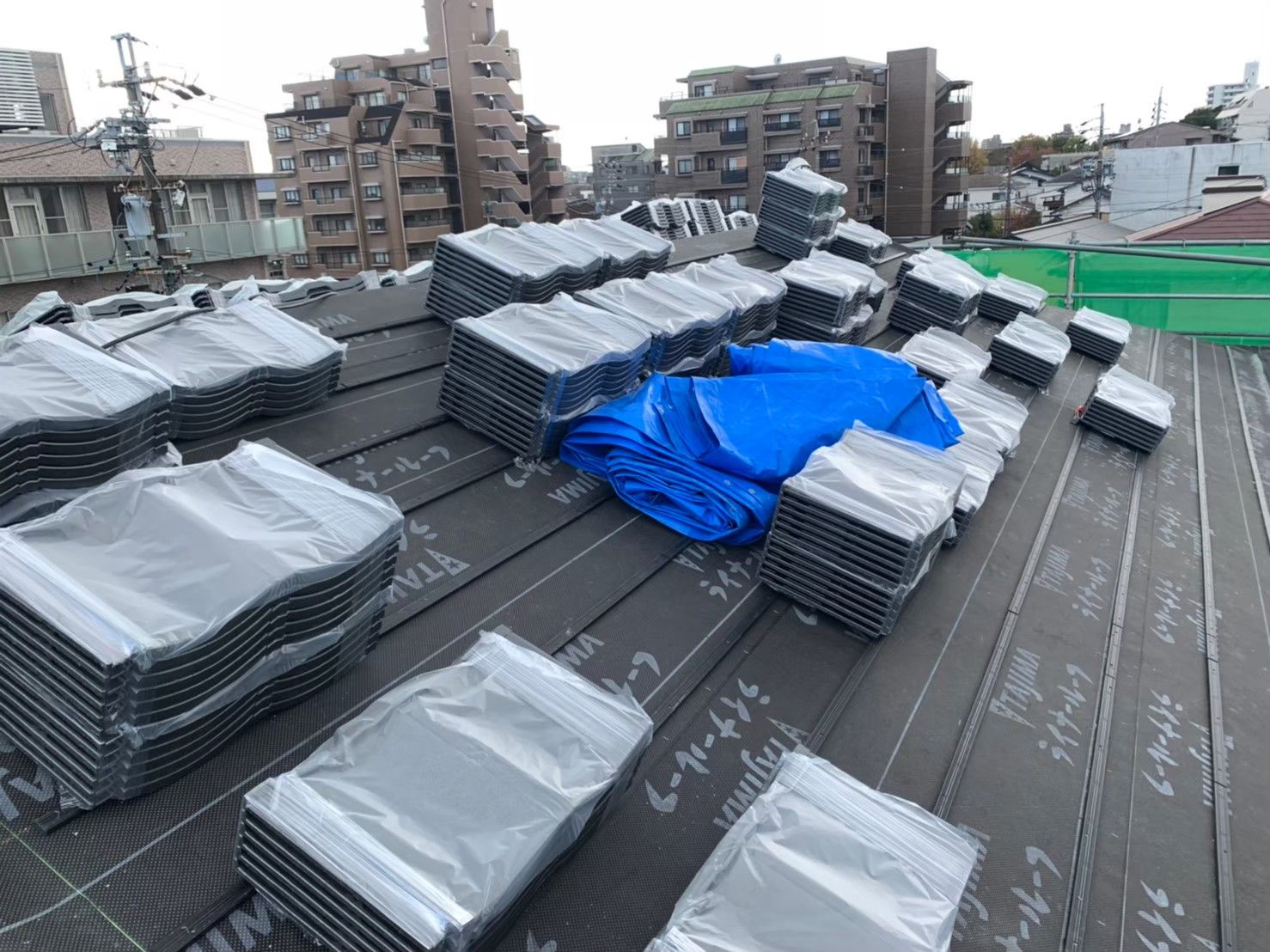 最新の屋根材を下部から順番に葺き上げる作業